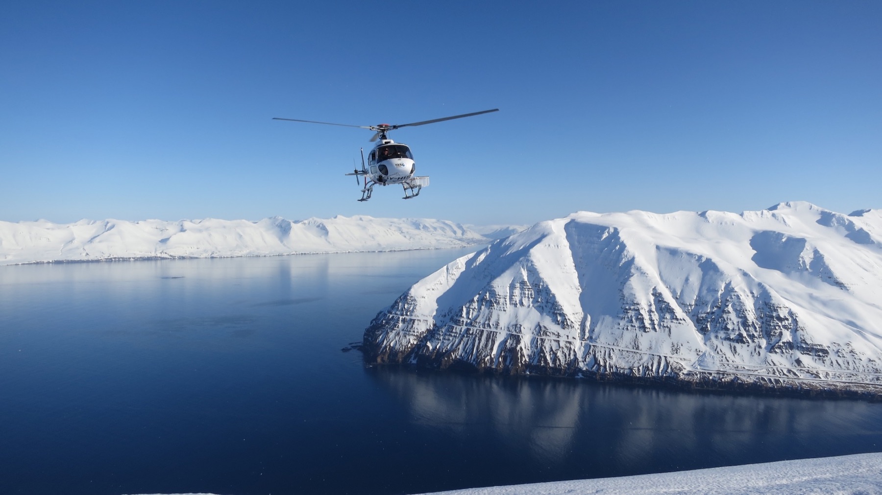 Viking-Helikopter über einem verschneiten Fjord